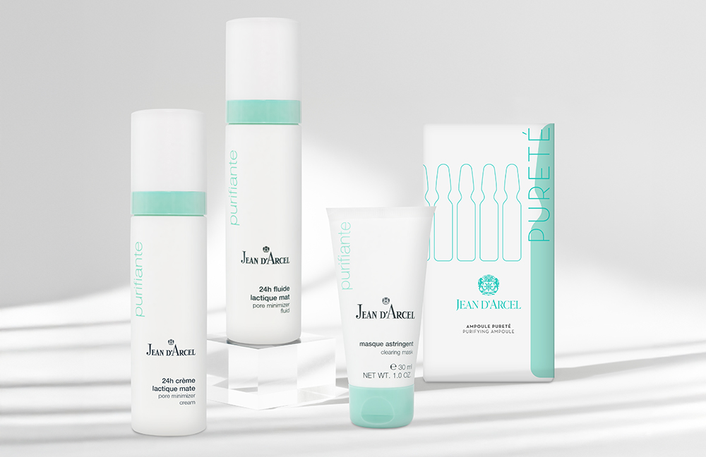 Abbildung einer Gesichtscreme, Maske, Ampullenbox und eines Fluids, nebeneinander auf hellem Untergrund arrangiert.